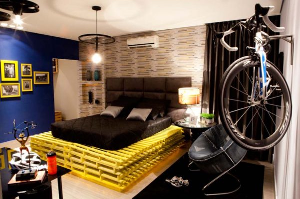 Base da cama feita com pallets e luminária a partir de roda de bicicleta no quarto do Rapaz, assinado por Lorena Coura e Rosemari Bragança